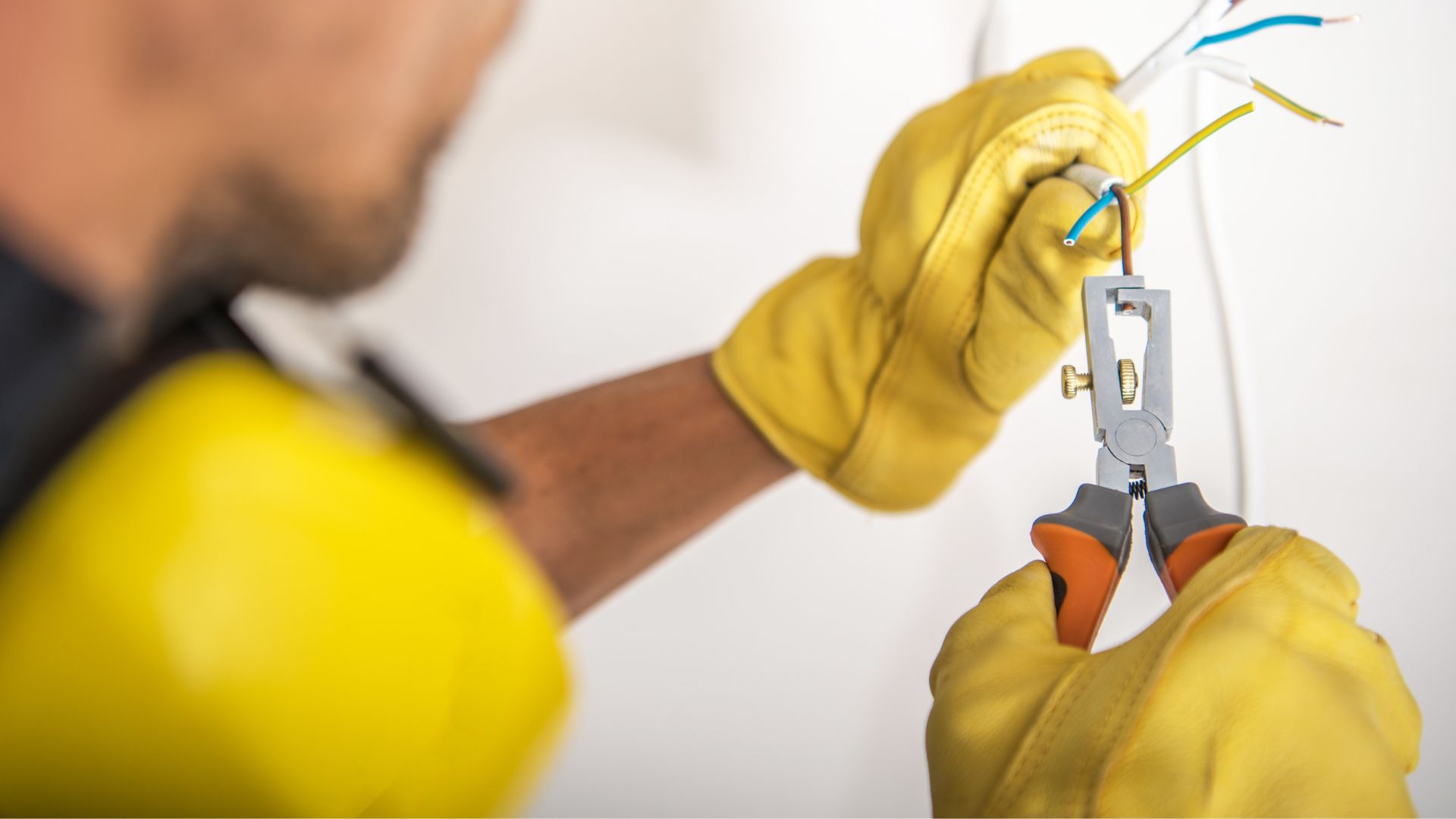 Elettricista Di Tota in fase di manutenzione impianto elettrico, mentre lavora su cavi con guanti e attrezzi professionali a Campobasso